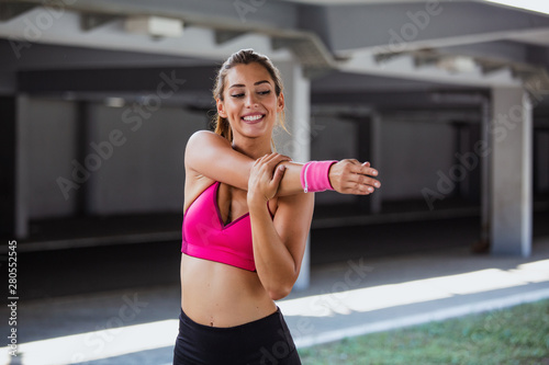 Fitness sport girl in fashion sportswear doing yoga fitness exercise in the street, outdoor sports, urban style. Young sporty woman training. Woman Doing Workout Exercises On Street.