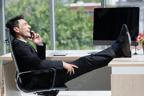Businessman sits and talking to smartphone..