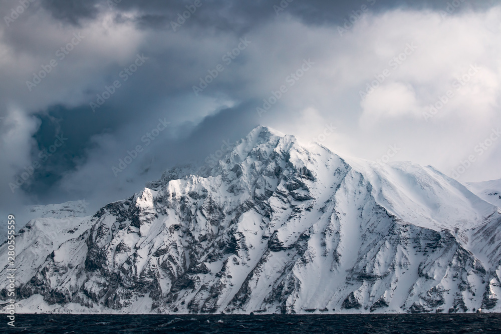 Φωτογραφία rocks on the mountains of one of the Kuril Islands in the winter during a snow s
