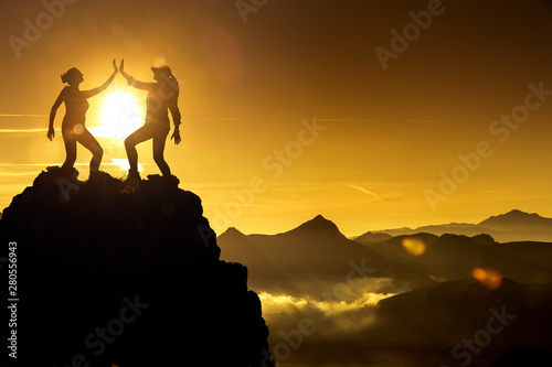 Zwei Frauen beim Abklatschen auf einem Berggipfel