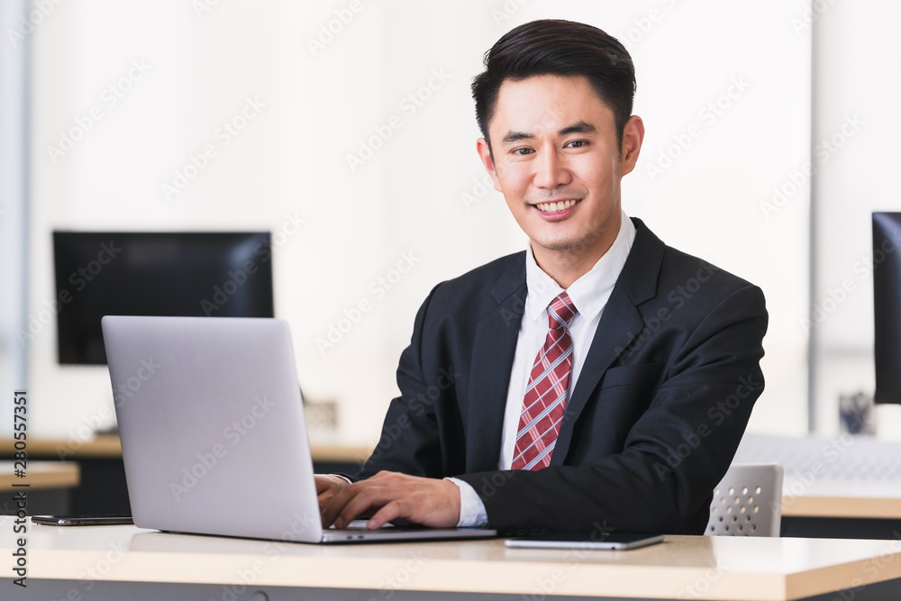 Asian businessman smiling and sittting in office,. Asian businessman smiling and sittting in office,.