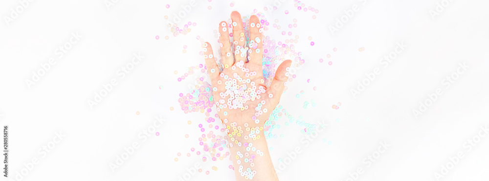 Fototapeta premium Pearl pastel confetti sparkles with woman hand