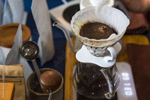 Close up of filter coffee maker, kettle with thermometer and digital scale on wooden table.Barista brewing coffee, method pour over, drip coffee.