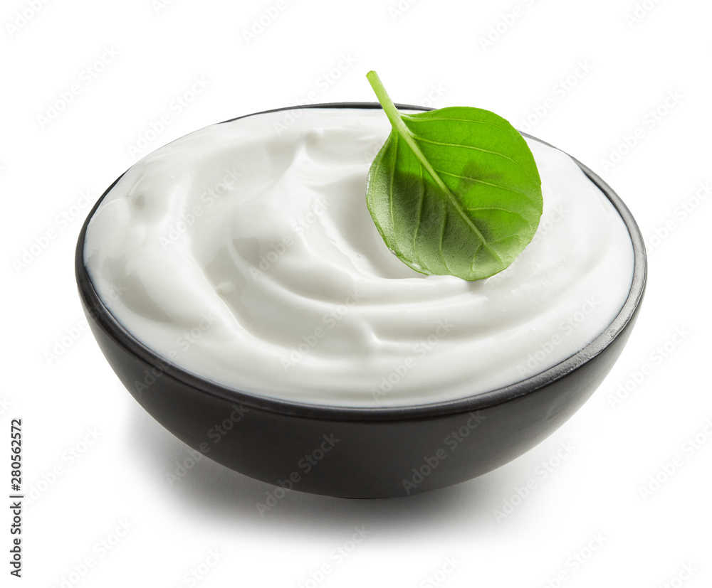 Sour cream with green leaf in black bowl isolated on white background Sour cream with green leaf in black bowl isolated on white background