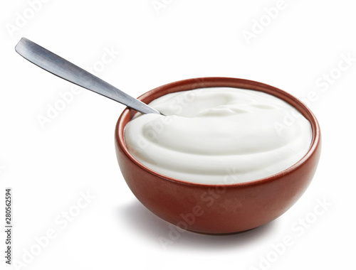 Sour cream with spoon in brown bowl isolated on white background