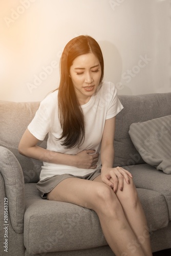 The girl holds her stomach with both hands. Stomach upset or pain during menstruation..