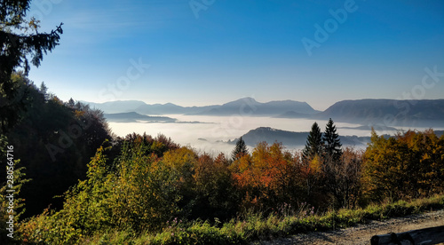 Wonderful view from mountains down to valey full of morning fog. photo