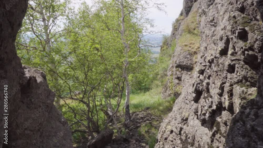 Handheld shot through the gorge in the rock. In the frame of the cable car with a cabin. Birch trees grow near the cliff. Handheld shot through the gorge in the rock. In the frame of the cable car with a cabin. Birch trees grow near the cliff.