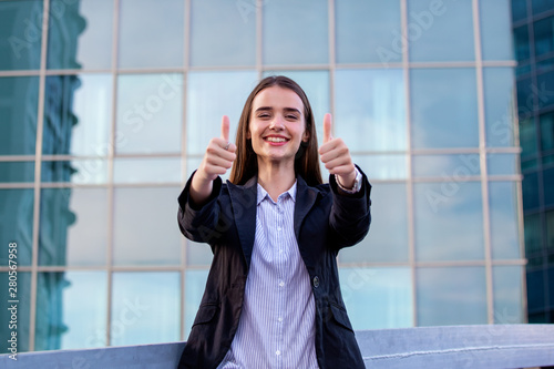 Confident young businesswoman giving the thumbs up. portrait of young business woman at modern startup company showing thumbs up