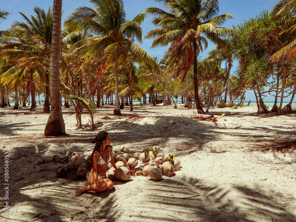 Woman holding coconut shells in the palm tree jungle in Onok island in ...
