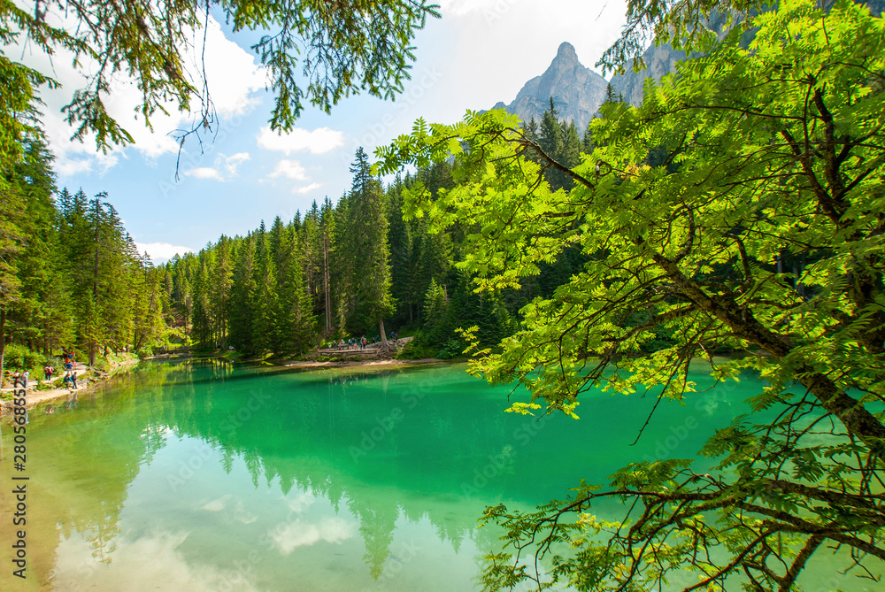 Fototapeta premium Turquoise water of the lake Lago di Braies, Pragser Wildsee surrounded by pine forest and mountains in the Prags Dolomites in South Tyrol, Italy, Europe