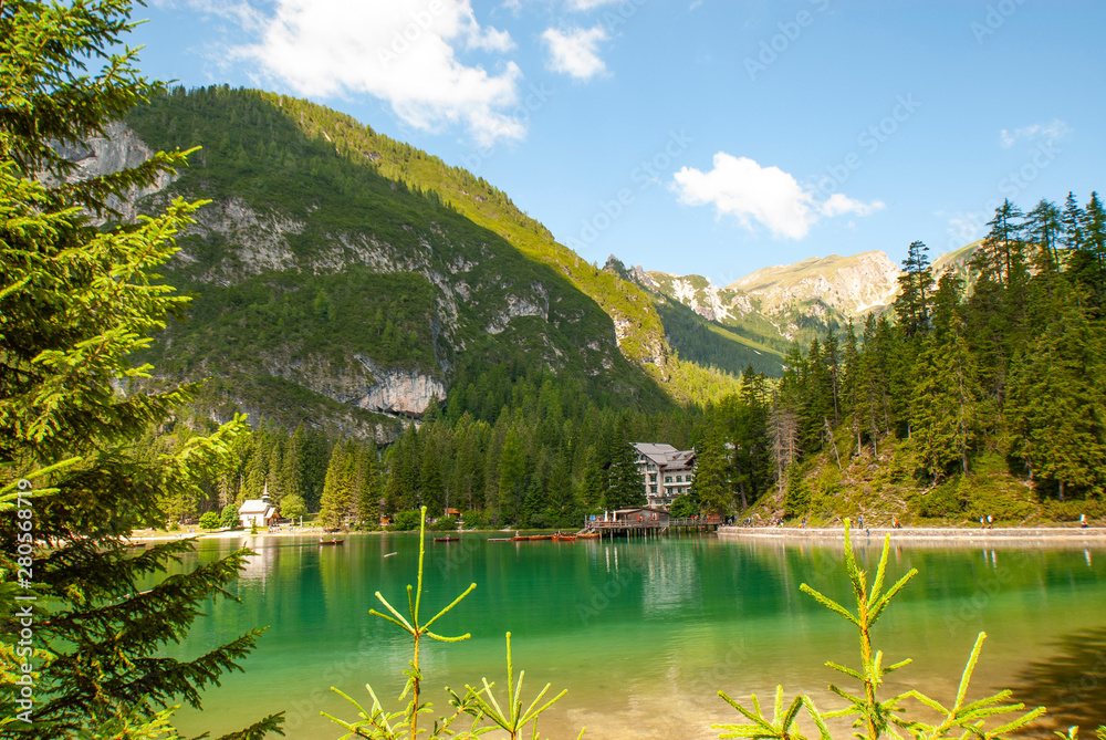 Turquoise water of the lake Lago di Braies, Pragser Wildsee surrounded by pine forest and mountains in the Prags Dolomites in South Tyrol, Italy, Europe