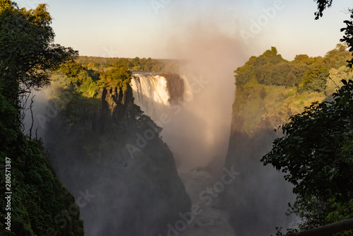 picture of the Victoria Falls and a rainbow while teh sun goes down  beautiful sunset