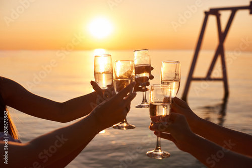 Fototapeta Naklejka Na Ścianę i Meble -  hen party before the wedding. girls relax at the resort. early morning friends drink champagne and meet the dawn on the ocean