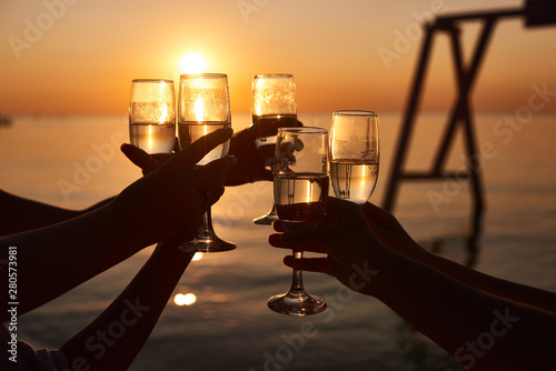Fototapeta Naklejka Na Ścianę i Meble -  hen party before the wedding. girls relax at the resort. early morning friends drink champagne and meet the dawn on the ocean
