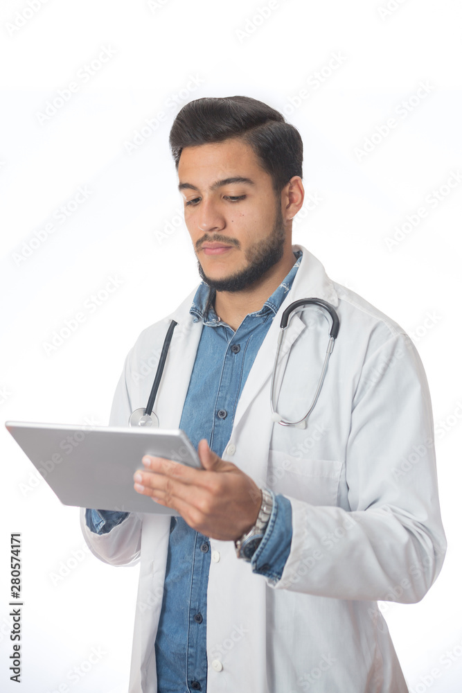 Young doctor in a portrait in studio. He is reading a patient history on his tablet.. Young doctor in a portrait in studio. He is reading a patient history on his tablet..