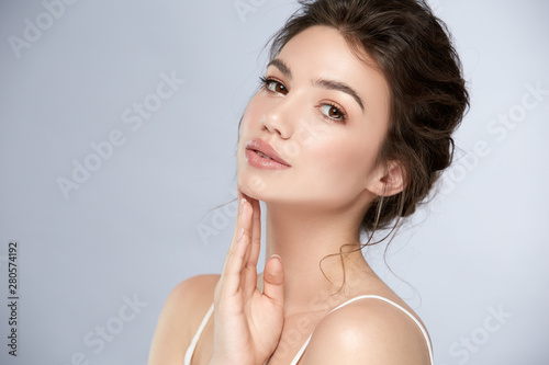 Fotografia fresh woman face with glossy lipstic and light make-up looking to camera