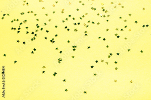 Gold stars with glitter on yellow background
