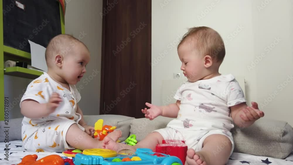 Fraternal twins girls sisters, playing with toys on the floor at home Fraternal twins girls sisters, playing with toys on the floor at home