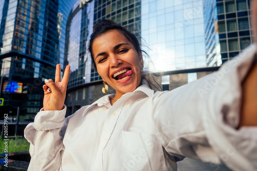 Photography beautiful india girl making selfie on the background of the business center Mosc