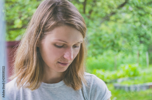 Portrait of a melancholic pensive woman against a background of nature