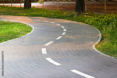 Tiled bike path. Curving sidewalk. Winding road.