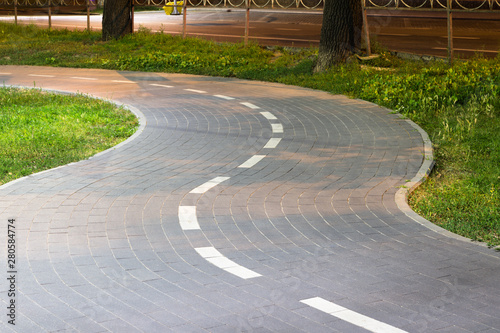 Tiled bike path. Curving sidewalk. Winding road.