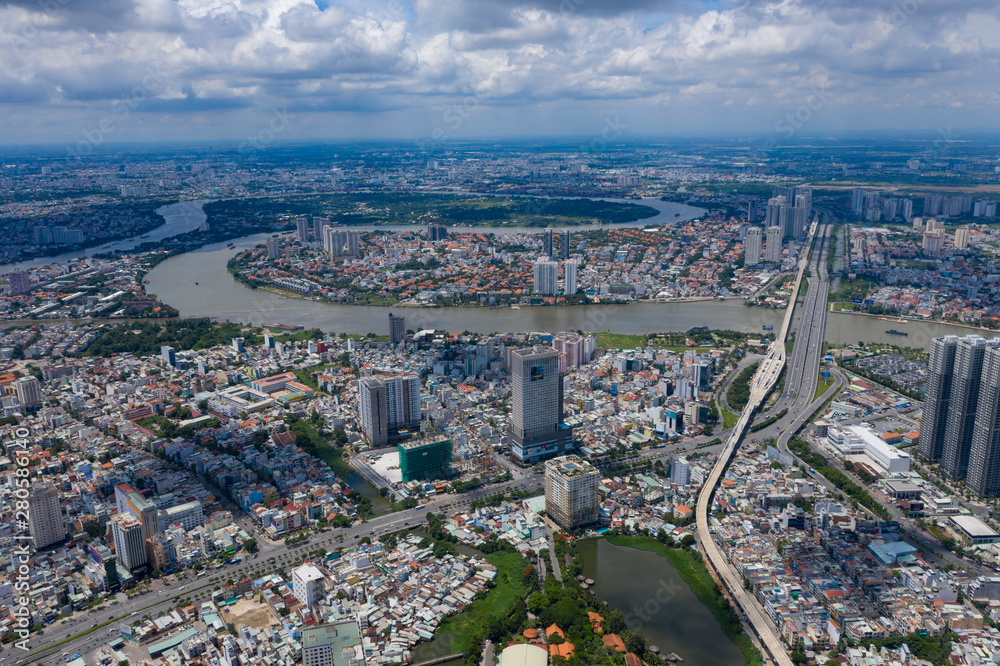 Fototapeta premium Top View of Building in a City - Aerial view Skyscrapers flying by drone of Ho Chi Mi City with development buildings, transportation, energy power 