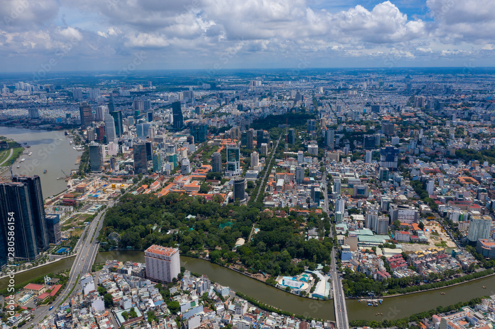 Fototapeta premium Top View of Building in a City - Aerial view Skyscrapers flying by drone of Ho Chi Mi City with development buildings, transportation, energy power