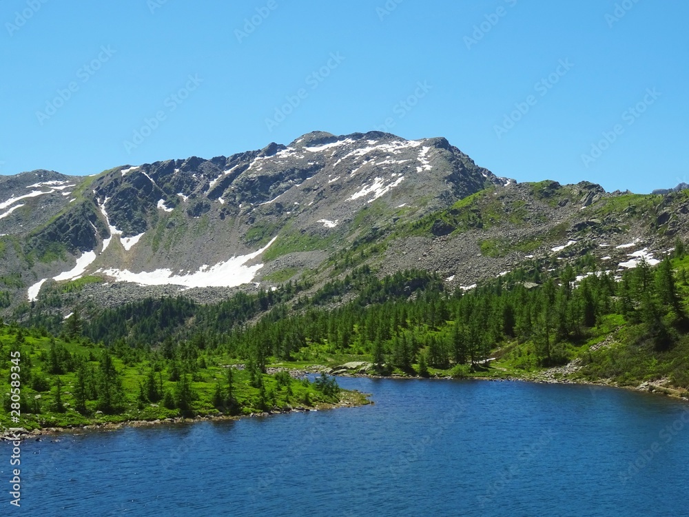 a lake in the Alps of Val Bognanco during a summer day, near the village of Domodossola, Italy - June 2019.