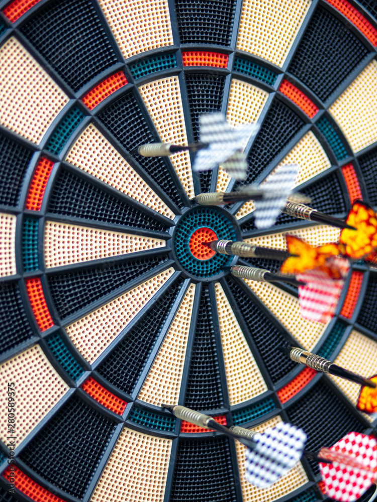 Picture of Darts arrow hitting in the target center of dartboard. concept business goal to marketing success. Business target or goal success and winner concept. success and risk management. Picture of Darts arrow hitting in the target center of dartboard. concept business goal to marketing success. Business target or goal success and winner concept. success and risk management.