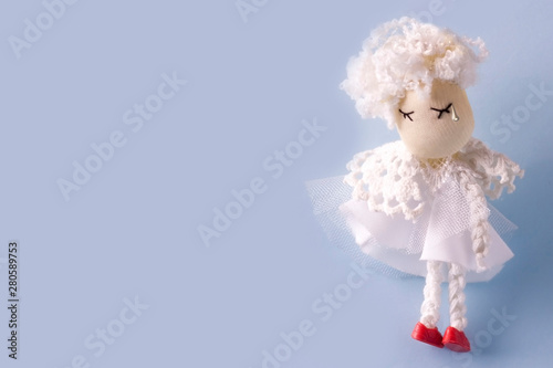 Mock up greeting card with sad cute angel handmade in white clothes on light blue background. Copy space