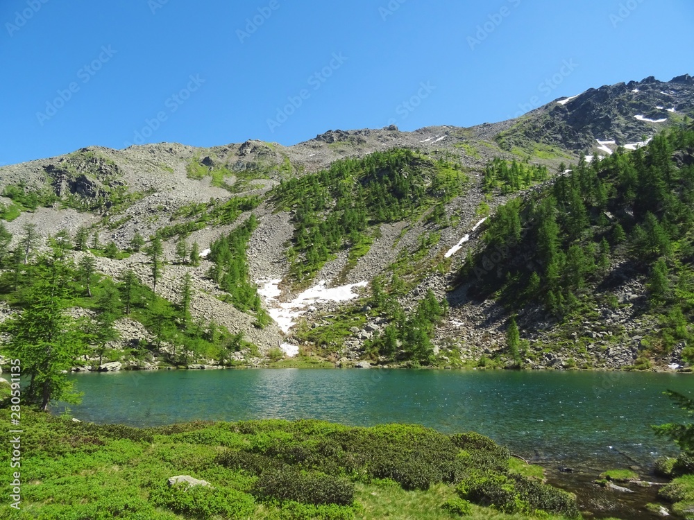 a lake in the Alps of Val Bognanco during a summer day, near the village of Domodossola, Italy - June 2019.