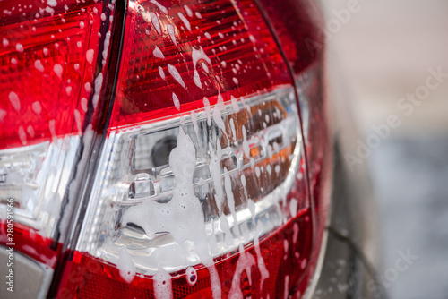 Cleaning car using high pressure water outdoors. photo