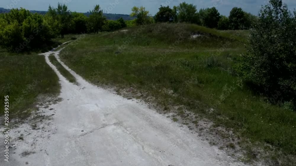 Narrow road through green grove. Narrow winding path going through green bushes and trees Narrow road through green grove. Narrow winding path going through green bushes and trees