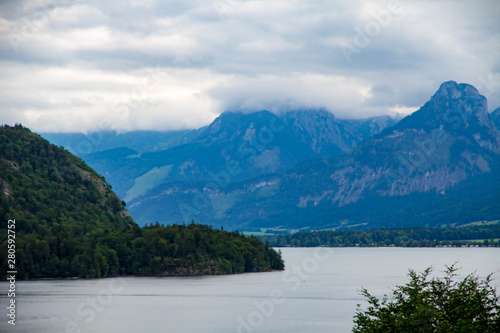 Calm cloudy day on lakefront of Attersee with mountains in background in late summer. lake Attersee in the Austrian Salzkammergut