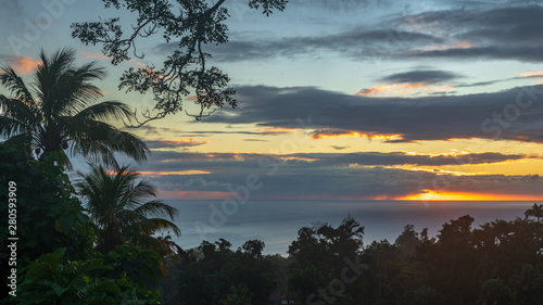 Coucher de soleil avec nuage au milieu de la verdure tropicale