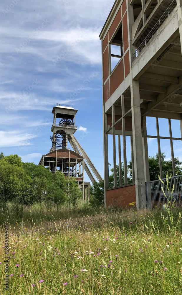 A disused coal mine pithead winding gear of an old Belgian coal mine shaft against a clear blue sky A disused coal mine pithead winding gear of an old Belgian coal mine shaft against a clear blue sky