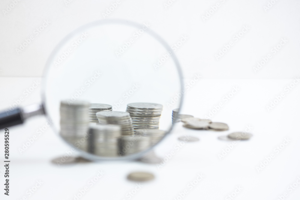 Stack of coins through magnifying glass. Save money. Business Finance concept Stack of coins through magnifying glass. Save money. Business Finance concept