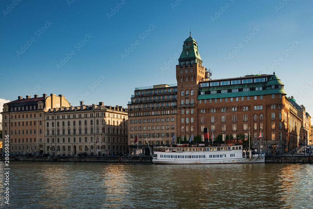 Fototapeta premium Buildings and ships along Nybrokajen embankment, Ostermalm district in central Stockholm, Sweden