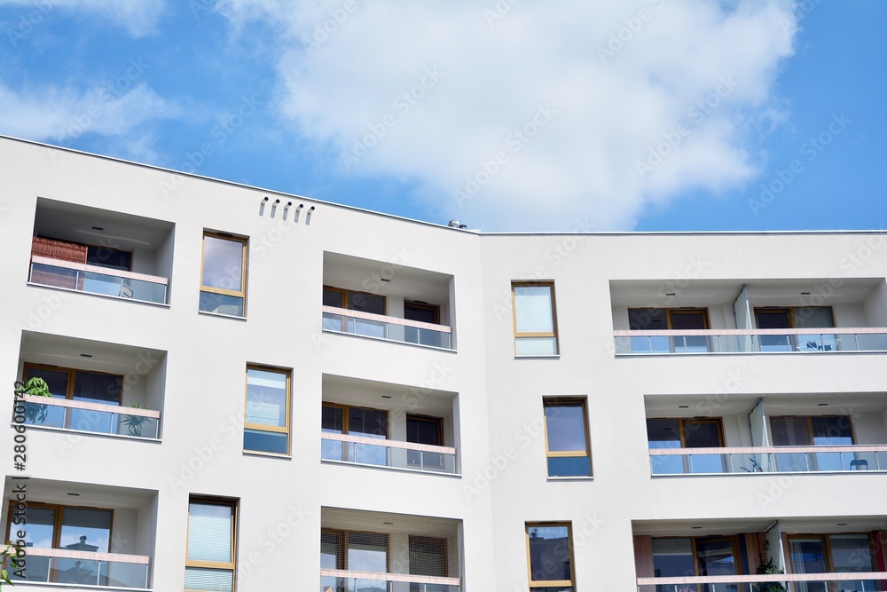 modern apartment building with blue sky and clouds modern apartment building with blue sky and clouds