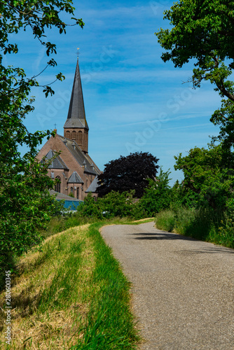 Cycle path to Parochie Hielige Suitbertus, Church in Beesd, The Netherlands photo