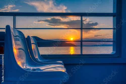 Fotografering magical sunset over the ferry boat on the island of thassos in greece