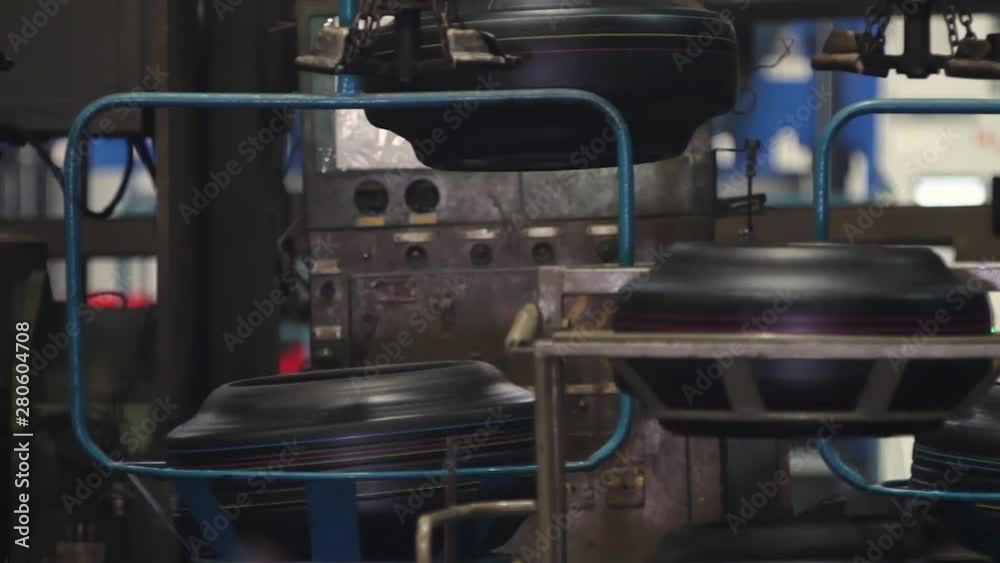 Conveyor with tires at factory. Tires production. Mechanical engineering and heavy industry. Automotive wheel molding in a factory. Manufacture of tyres. Tyre production machine conveyor. Conveyor with tires at factory. Tires production. Mechanical engineering and heavy industry. Automotive wheel molding in a factory. Manufacture of tyres. Tyre production machine conveyor.