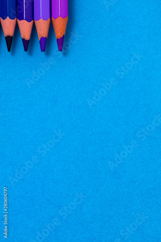 four color pencil on top with blue paper background