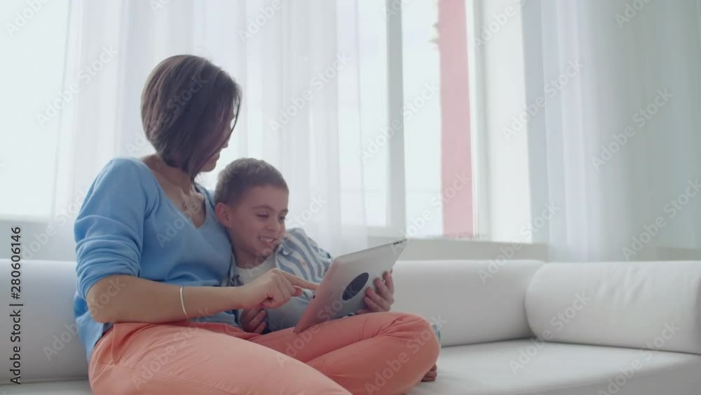 Mother and son playing with digital tablet at home. Young mother with her 5 years old smiling with digital tablet at home. Mother and son playing with digital tablet at home. Young mother with her 5 years old smiling with digital tablet at home.