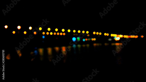 the light at the bridge shines with different colours against the dark night
