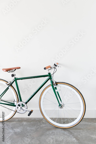 Fixed Green and Brown Bicycle in Modern Home, Fixie Bike inside hous​e, white wall background, isolated retro bicycle 