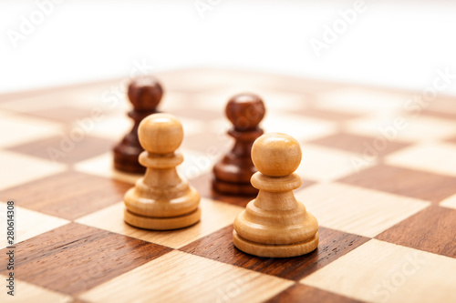 Chess pawns on a chessboard table on a white background