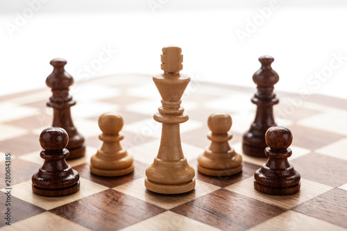 wooden white chess king between other pieces